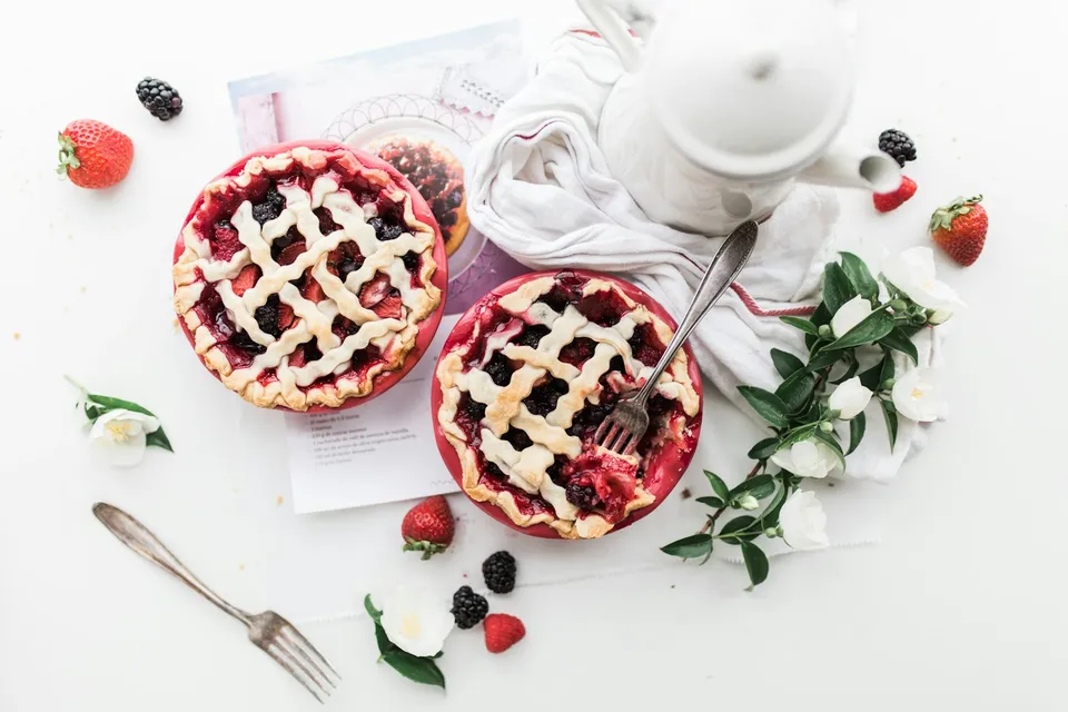 Tortinhas de frutas e uma xícara de chá em uma mesa clara